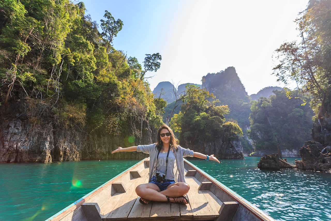 our-services-2 Asian woman relishing a serene boat journey through the lush karst landscape of Thailand's Khlong Sok.