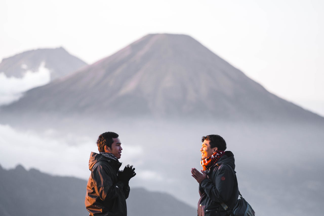 contact-img Two men enjoy a scenic hike on Indonesia's Gunung Prau, surrounded by misty mountains at sunrise.